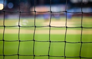 Close up image of sport netting against grass sports pitch. 