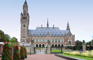 The Peace Palace in the Hague - a 1900s building in red and white brick, with a tall narrow clocktower